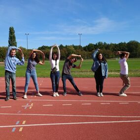 défi photo d'étudiants sur une piste d'athlétisme lors des olympiades de journée d'intégration