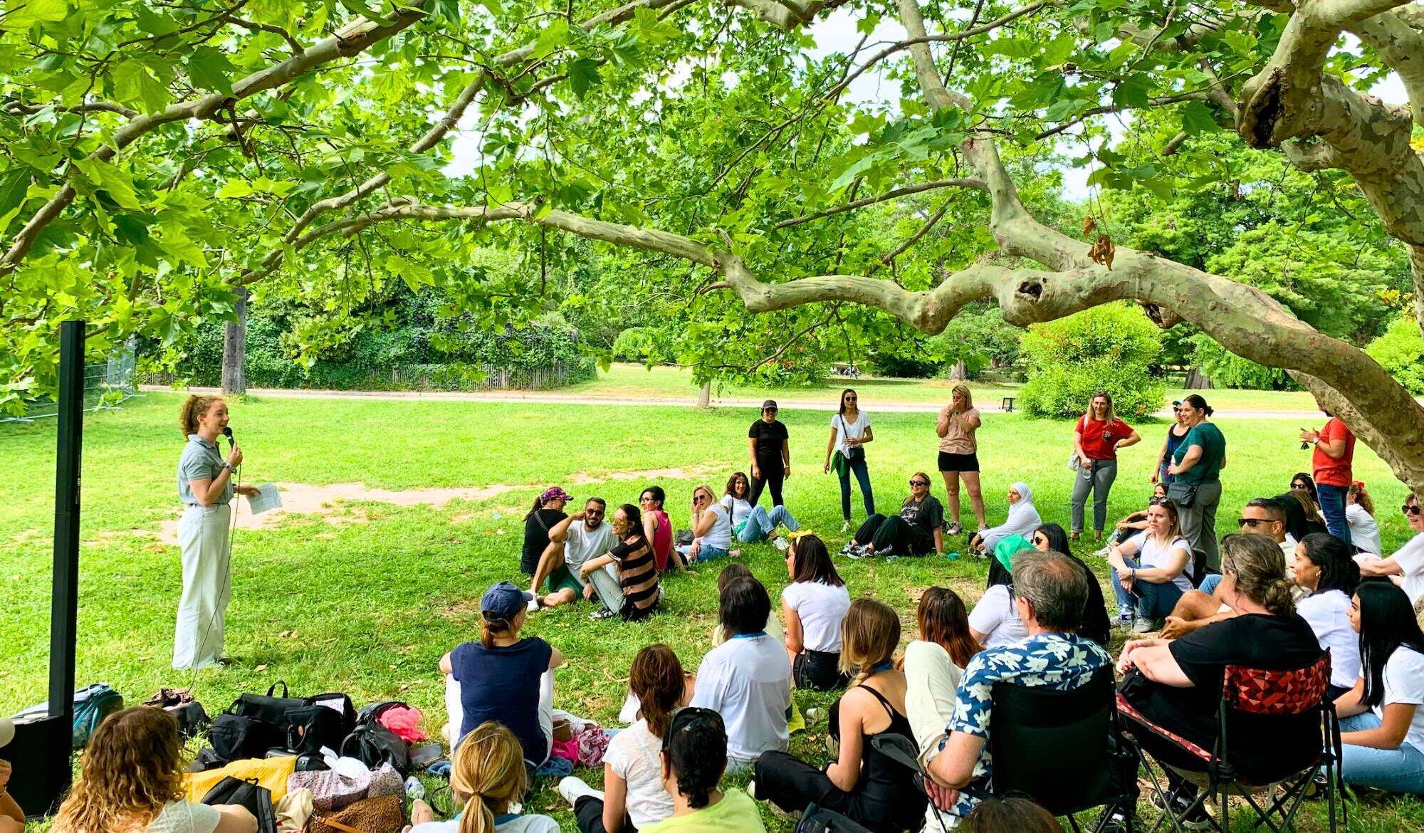 Animatrice qui présente une activité pour un team building RSE à des collaborateurs dans un parc