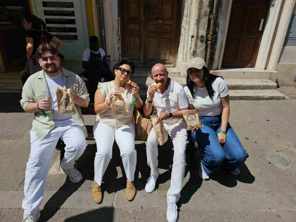 Une équipe savourant sa dégustation sur un banc lors d'une aventure gourmande à Marseille