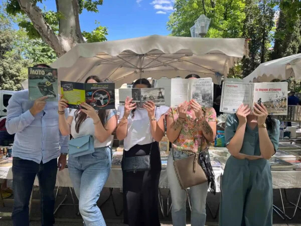 Equipe posant pour une photo originale derrière des livres ouverts