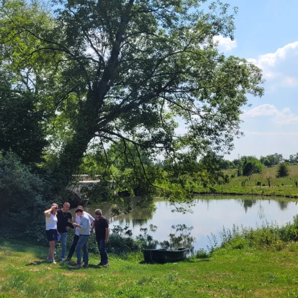 Equipe répondant à une énigme de course d'orientation au pied d'un lac