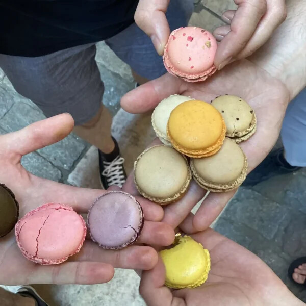 Une équipe tient dans la main des macarons récupérés pendant un rallye gourmand