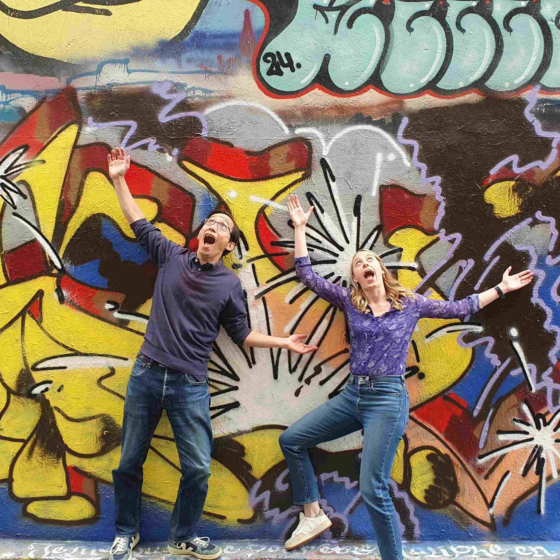 Photo de deux collaborateurs qui font une pose devant une oeuvre de Street Art lors d'un team building à Roubaix