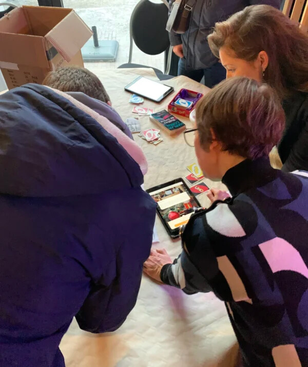 Equipe décodant une énigme sur une table, pendant un jeu d'enquête collaboratif