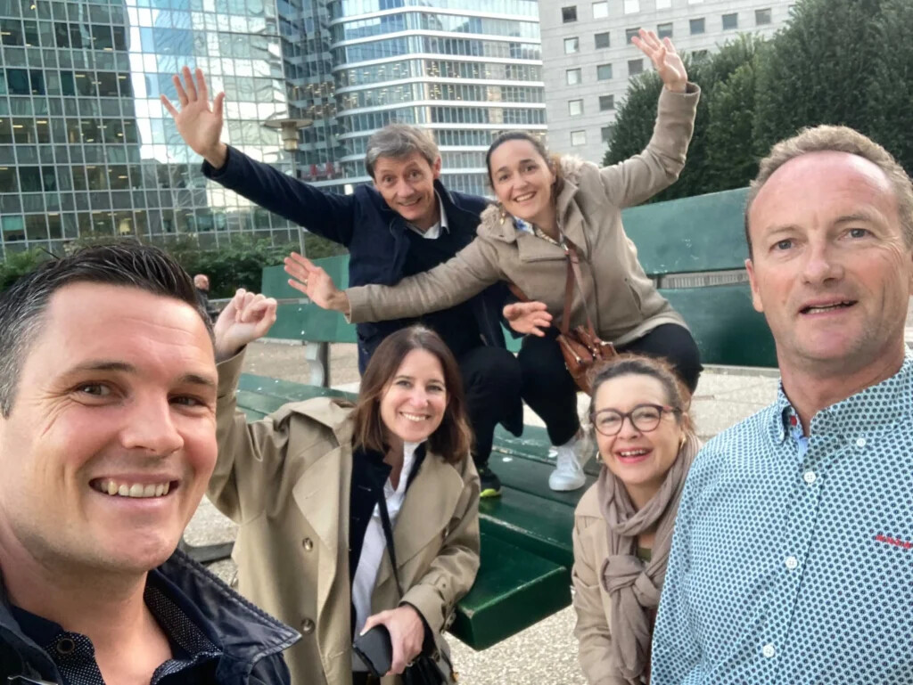 Une équipe réalisant un défi photo sur une sculpture street-art de la Défense